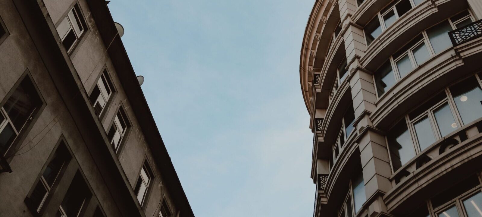 Low angle view of modern city architecture against blue sky, highlighting geometric design.