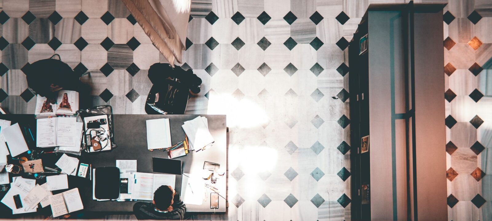 High-angle shot of a modern workspace with people and geometric patterned floor.