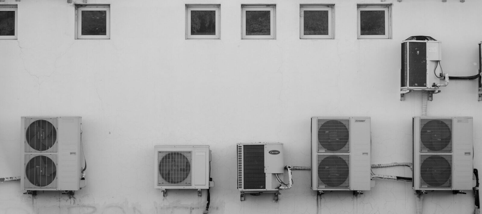 Black and white image of air conditioners mounted on a building facade in Córdoba, Argentina.
